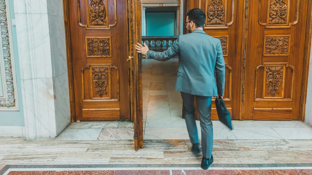 professionnel en costume qui ouvre une porte