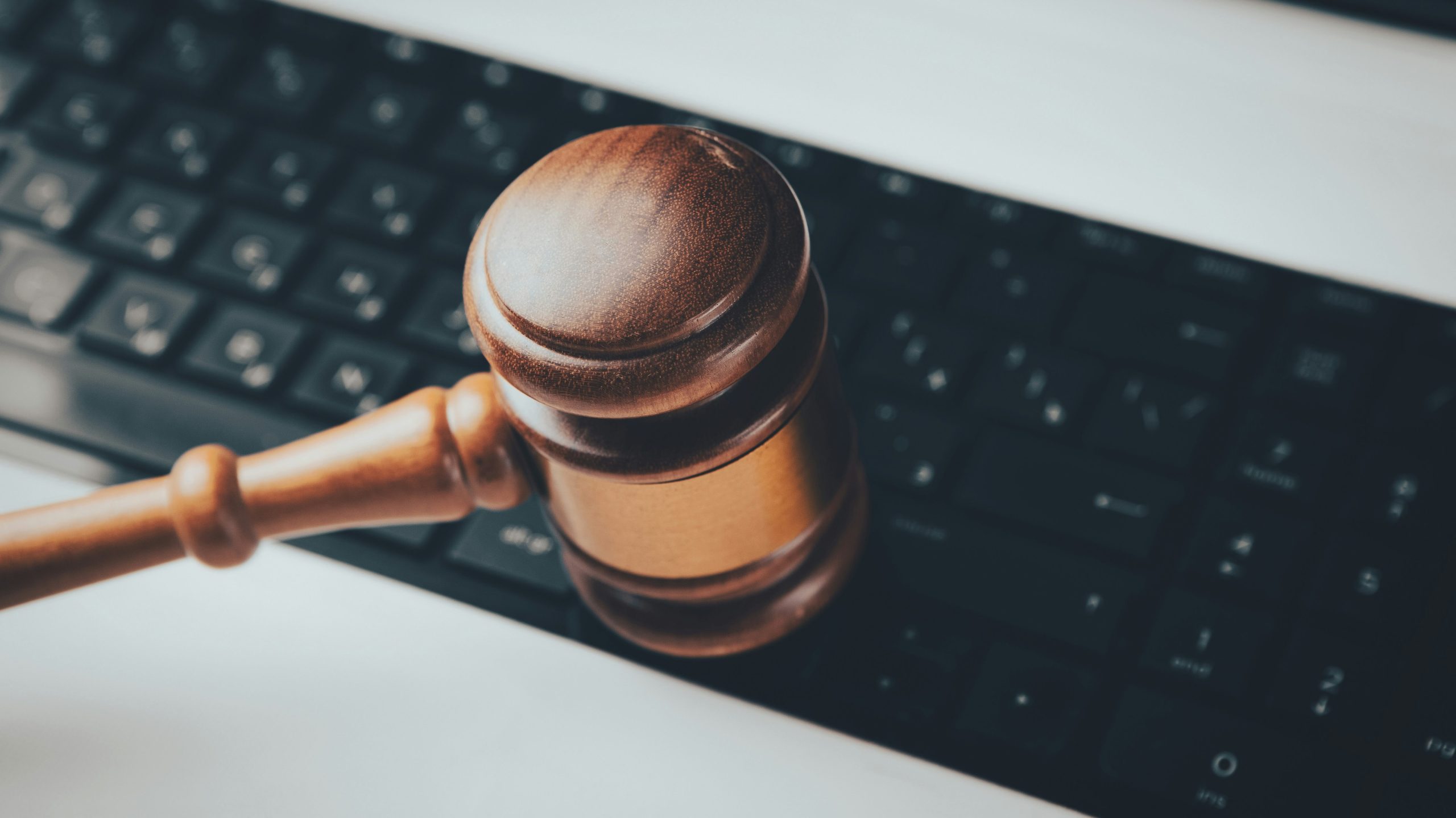 marteau de loi en bois devant un clavier d'ordinateur