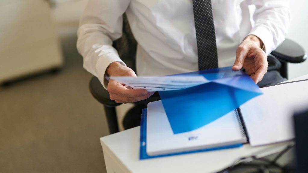 homme en costard qui tient un document à son bureau